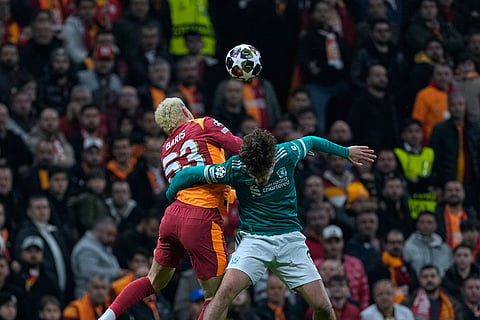 Galatasaray's Baris Yilmaz, left, fights for a high ball with Liverpool's Milos Kerkez during a Champions League round of 16 first leg soccer match between Galatasaray and Liverpool, in Istanbul, Turkey.