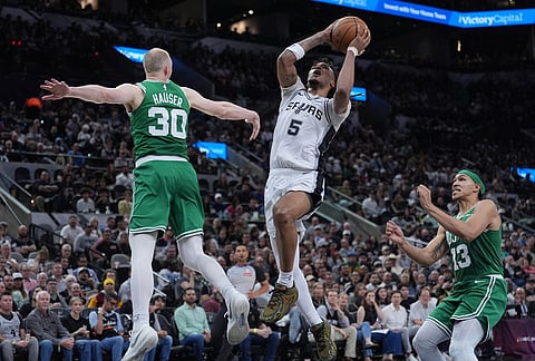 San Antonio Spurs guard Stephon Castle (5) drives to the basket against Boston Celtics forward Sam Hauser (30) during the second half of an NBA basketball game in San Antonio.