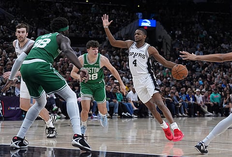 San Antonio Spurs guard De'aaron Fox (4) drives past Boston Celtics guard Hugo Gonzalez (28) during the second half of an NBA basketball game in San Antonio.