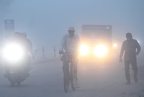 Commuters move through morning fog, in Dehradun, Uttarakhand. Dense fog reduced visibility in the city. 