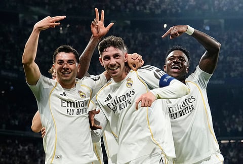 Real Madrid's Federico Valverde, center, celebrates after scoring his third goal during a first leg round of 16 Champions League soccer match between Real Madrid and Manchester City in Madrid, Spain.