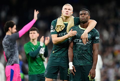 Manchester City's Erling Haaland, left, and Marc Guehi walk off the pitch after a first leg round of 16 Champions League soccer match between Real Madrid and Manchester City in Madrid, Spain.