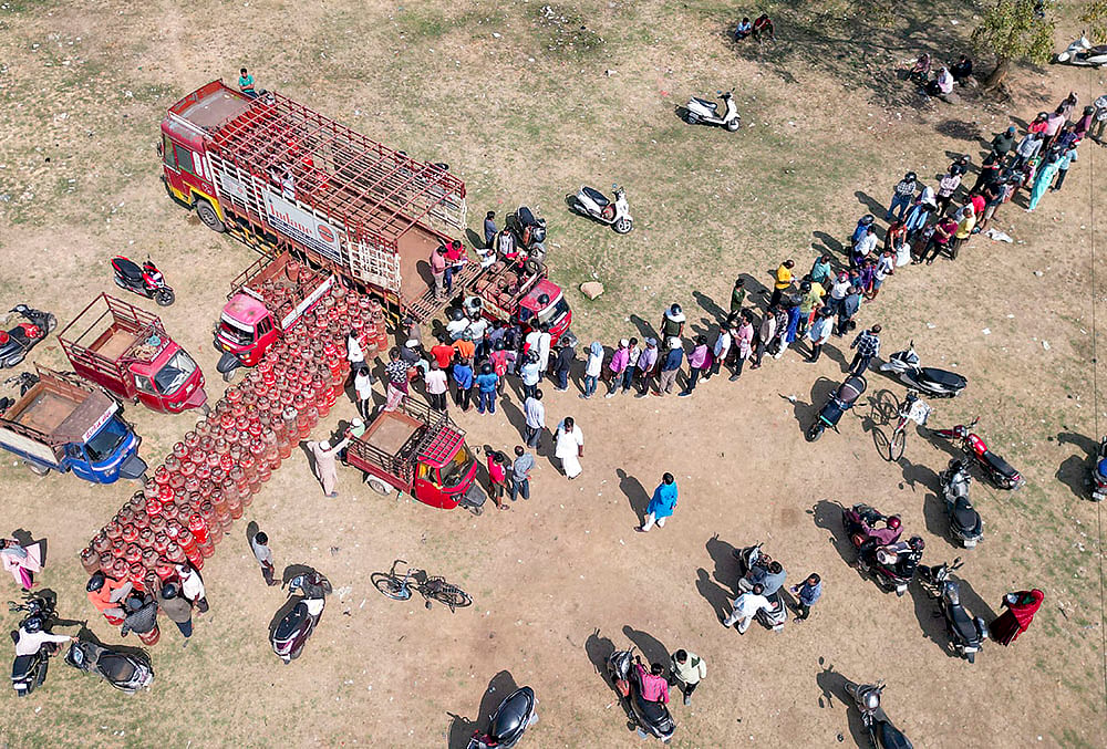 | Photo: PTI : People waiting outside the distribution points said that vehicles carrying gas cylinders had not been arriving in the area regularly. This has left many families worried about their cooking needs.