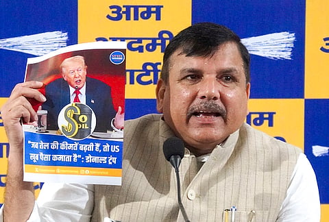 AAP MP Sanjay Singh shows a poster during a press conference, at party office in New Delhi. 