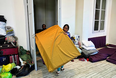 A displaced migrant woman who among many others fled Israeli strikes in southern and eastern Lebanon and Beirut's southern suburbs carries mattresses at Saint Joseph Church, which has been turned into a shelter for displaced migrants, mostly from African nations, in Beirut, Wednesday, March 11, 2026.
