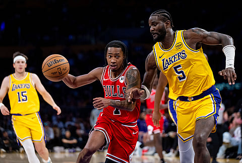 Chicago Bulls guard Rob Dillingham (7) drives the ball against Los Angeles Lakers center Deandre Ayton (5) during the second half of an NBA basketball game, in Los Angeles.