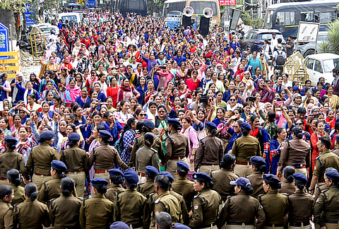 Police personnel stop anganwadi workers during a protest over various demands, in Dehradun. 