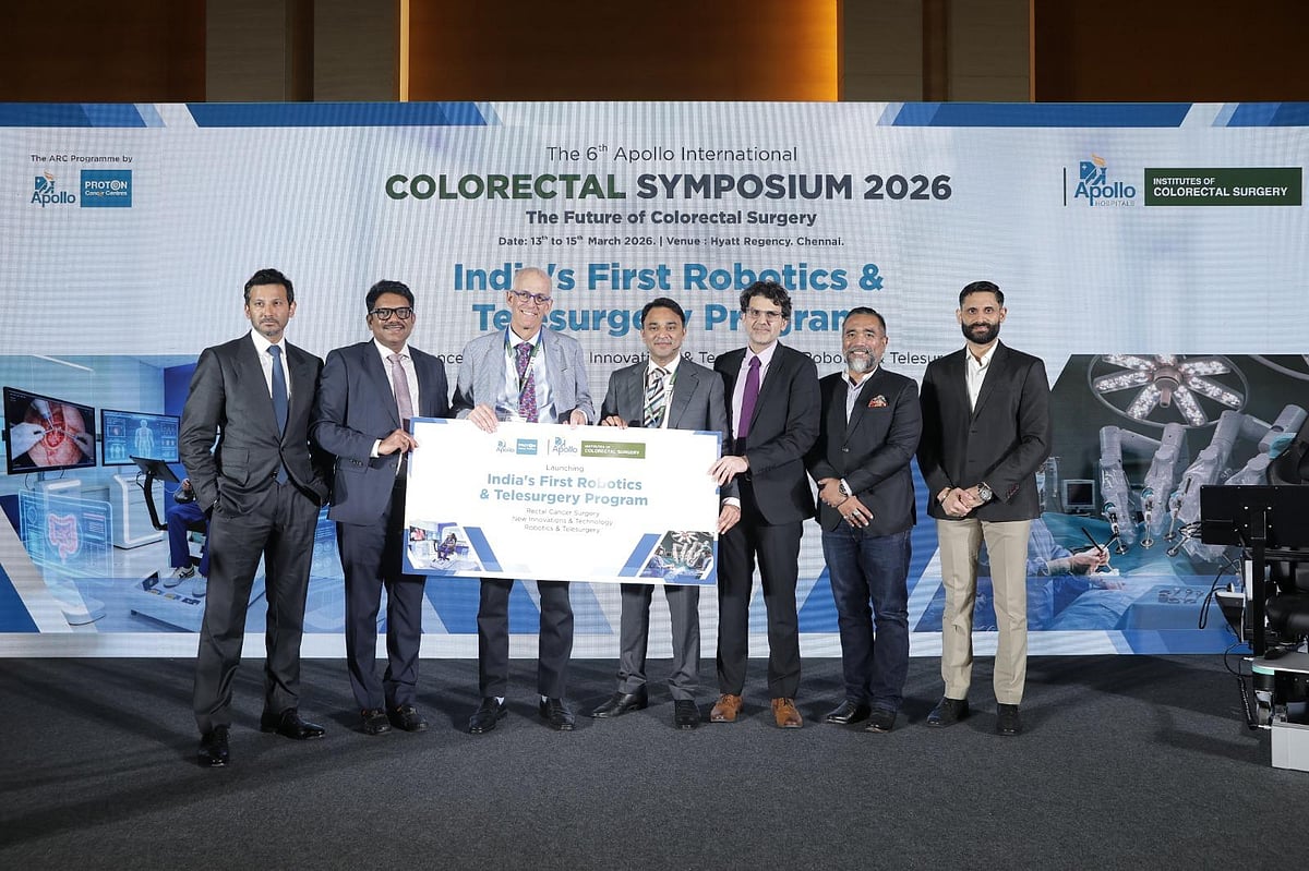 Seven men in suits posing on a stage at the 6th Apollo International Colorectal Symposium 2026.
