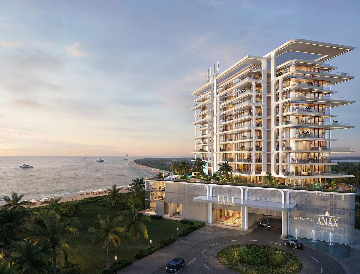 Modern waterfront apartment building with tiered balconies at twilight.