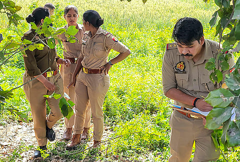 Police officials inspect the site after three people were found dead near a railway line, in Bulandshahr, Uttar Pradesh.