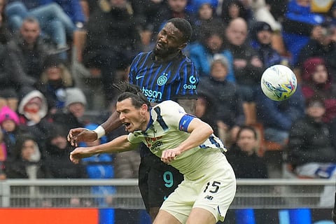 Inter Milan's Marcus Thuram, top, and Atalanta's Marten de Roon jump for the ball during the Serie A soccer match between Inter Milan and Atalanta in Milan, Italy.