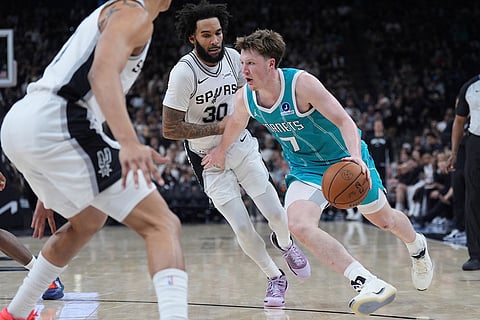 Charlotte Hornets guard Kon Knueppel (7) drives around San Antonio Spurs forward Julian Champagnie (30) during the second half of an NBA basketball game in San Antonio.