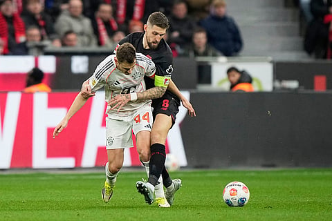 Bayern's Josip Stanisic, left, challenges for the ball with Leverkusen's Robert Andrich during a German Bundesliga soccer match between Bayer Leverkusen and Bayern Munich in Leverkusen, Germany.