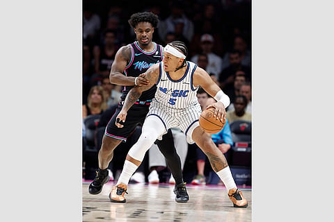 Miami Heat guard Davion Mitchell, left, defends Orlando Magic forward Paolo Banchero (5) during the second half of an NBA basketball game in Miami.