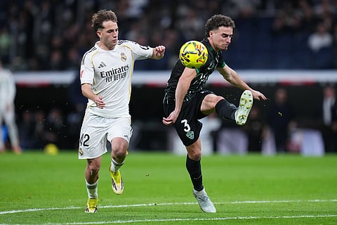 Elche's Adria Pedrosa, right, is challenged by Real Madrid's Daniel Yanez during a Spanish La Liga soccer match between Real Madrid and Elche CF, in Madrid.