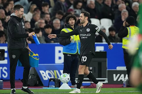 Manchester City's Bernardo Silva, right, reacts after scoring his side's opening goal during the English Premier League soccer match between West Ham United and Manchester City in London, England.
