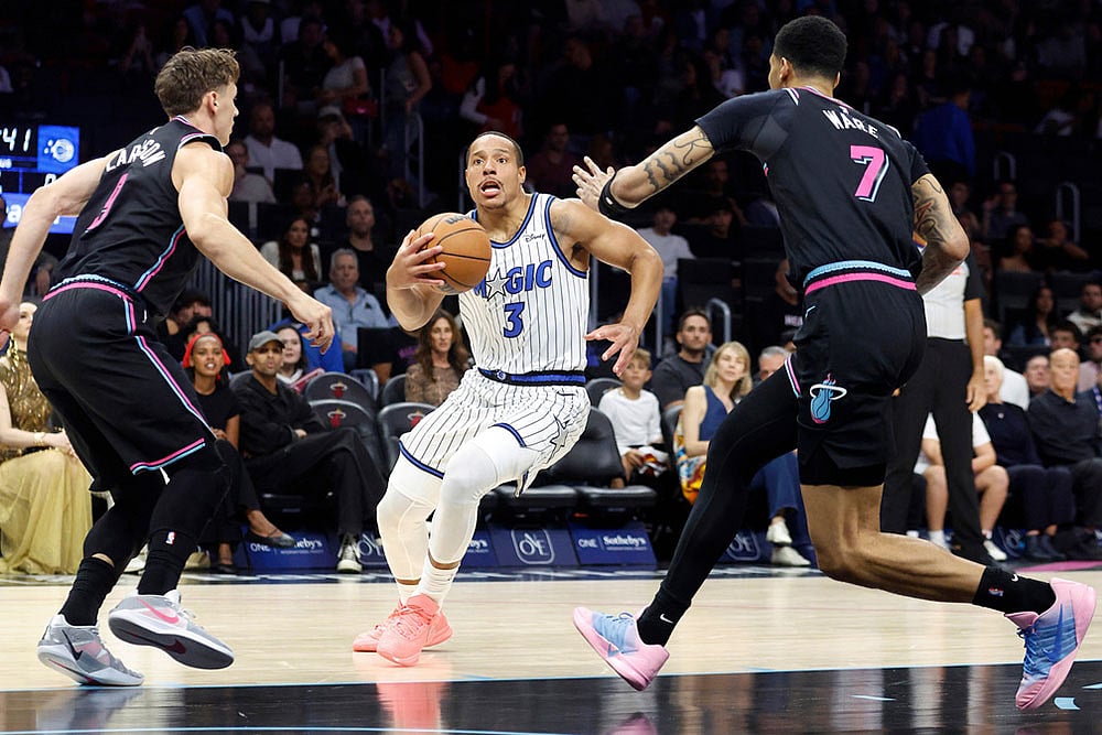 | Photo: AP/Rhona Wise : Miami Heat guard Pelle Larsson (9) and Miami Heat Kel'el Ware (7) defend Orlando Magic guard Desmond Bane (3) during the first half of an NBA basketball game in Miami.