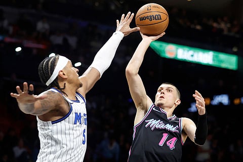 Miami Heat guard Tyler Herro (14) shoots over Orlando Magic forward Paolo Banchero (5) during the second half of an NBA basketball game in Miami.