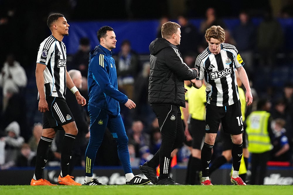 | Photo: John Walton/PA via AP : Newcastle United's Anthony Gordon, right, is congratulated by manager Eddie Howe following victory in the Premier League match between Chelsea and Newcastle, in London.
