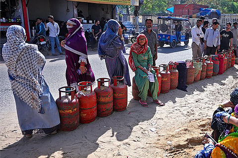 People wait in a queue with LPG cylinders amid a supply crisis, in Jaipur