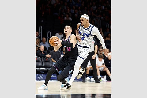 Orlando Magic guard Jalen Suggs (4) defends Miami Heat guard Tyler Herro (14) during the second half of an NBA basketball game in Miami.