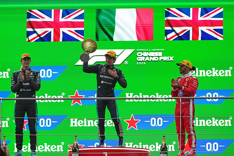 Race winner Mercedes driver Andrea Kimi Antonelli of Italy, center, celebrates on the podium with second placed Mercedes driver George Russell of Britain, left, and third placed Ferrari driver Lewis Hamilton.
