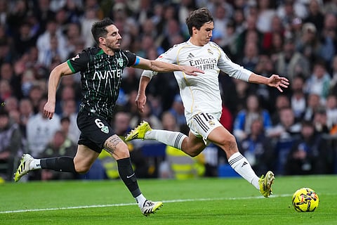 Real Madrid's Gonzalo Garcia, right, is challenged by Elche's Pedro Bigas during a Spanish La Liga soccer match between Real Madrid and Elche CF, in Madrid.