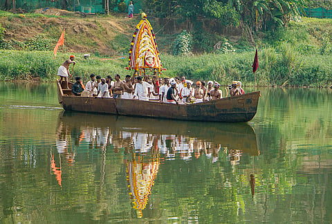 People carry sacred articles of goddesses Bhagavati, Bhadrakali and Arasu across the Phalguni River by boat after a ceremonial programme at Polali Sri Raja Rajeshwari Temple, in Mangaluru.