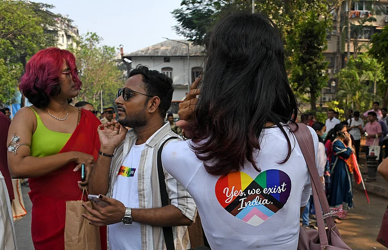 A member of Lesbian Gay Bisexual Transgender and Queer (LGBTQ) community wearing a t-shirt that reads "Yes, we exist India" as seen outside August Kranti Maidan, celebrating 16 years of the official pride march in Mumbai. The rainbow flag signifies joy but the march remains a protest at its core demanding the fundamental rights still denied to the LGBTQ community in India. - null