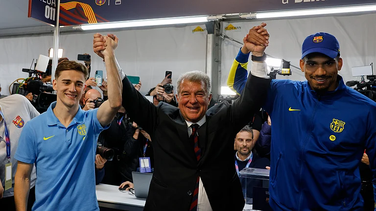 Joan Laporta, center, reacts as he poses with players Gavi, left, and Ronald Araujo after the voting for the election to be president of FC Barcelona in Barcelona, Spain, Sunday, March 15, 2026. - (AP Photo/Joan Monfort)