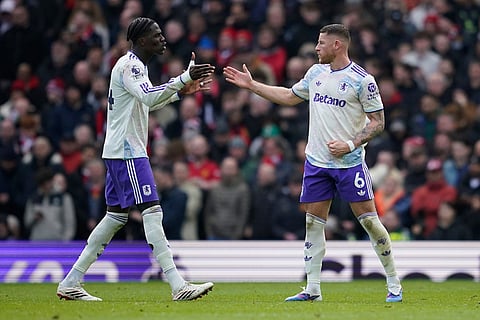 Aston Villa's Amadou Onana, left, and Ross Barkley react after a goal during the Premier League soccer match between Manchester United and Aston Villa in Manchester, England.