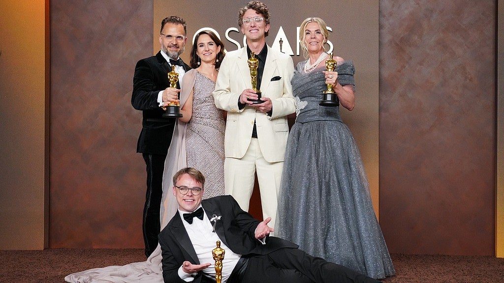 (Photo by Jordan Strauss/Invision/AP) : Pavel Talankin, front center, and Radovan Sibrt, top left, Alzbeta Karaskova, David Borenstein, and Helle Faber, winners of the award for documentary feature film for "Mr. Nobody against Putin," pose in the press room at the Oscars on Sunday, March 15, 2026, at the Dolby Theatre in Los Angeles. 
