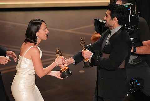 Natalie Musteata, left, accepts the award for live action short film for "Two People Exchanging Saliva" from Kumail Nanjiani during the Oscars at the Dolby Theatre in Los Angeles.