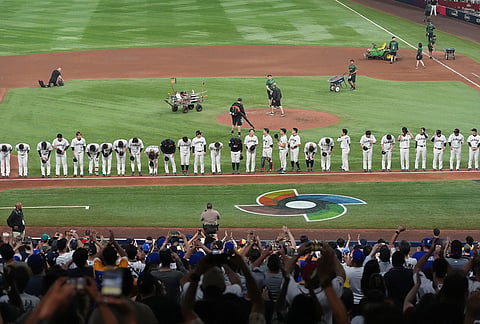 Japan team line up to greet three fans after after a World Baseball Classic quarterfinal game against Venezuela in Miami.