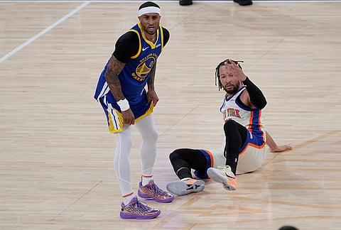 New York Knicks' Jalen Brunson, right, and Golden State Warriors' Gary Payton II react after Payton II fouled Brunson during the second half of an NBA basketball game in New York.