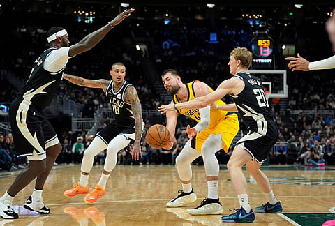 Indiana Pacers' Ivica Zubac, second from right, passes around Milwaukee Bucks' AJ Green, right, Kyle Kuzma (18), and Bobby Portis, left, during the first half of an NBA basketball game, in Milwaukee. 