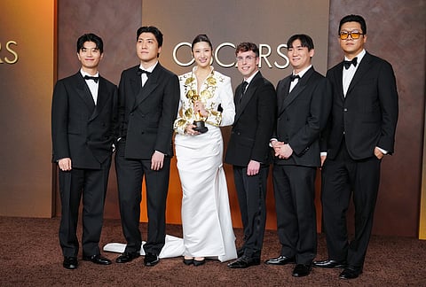 Yu Han Lee, from left, Joong Gyu Kwak, EJAE, Mark Sonnenblick, Hee Dong Nam, and Jeong Hoon Seo, winners of the award for music (original song) for "Golden" from "K-pop Demon Hunters," pose in the press room at the Oscars at the Dolby Theatre in Los Angeles. 
