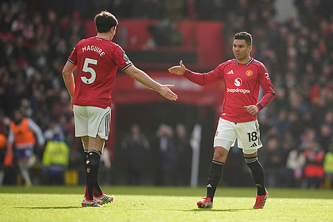 Manchester United's Harry Maguire and Casemiro celebrate after a goal during the Premier League soccer match between Manchester United and Aston Villa in Manchester, England.