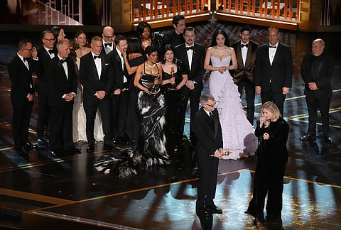 Paul Thomas Anderson, left center, Sara Murphy, right center, and the team from "One Battle After Another" accept the award for best picture during the Oscars at the Dolby Theatre in Los Angeles. 