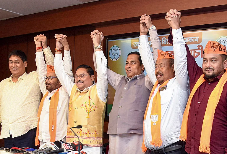 Assam BJP President Dilip Saikia joins hands with newly joined party leader Bhupen Roy and other leaders during a press conference, in Guwahati. - | Photo: PTI