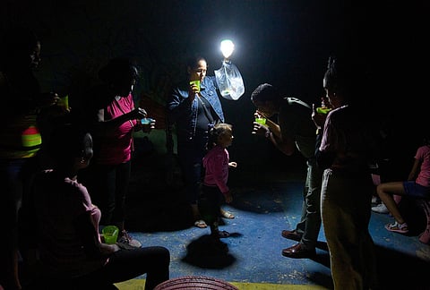 A man gives a girl a spoonful of soup on a street during a blackout in Havana, Wednesday, March 4, 2026. 