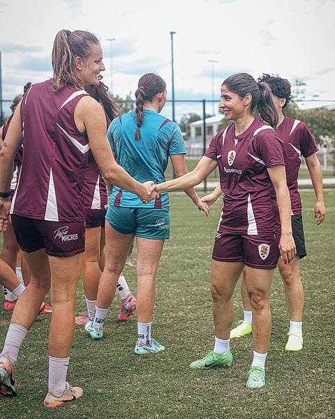 Iranian soccer player Atefeh Ramezanisadeh, right, is welcomed to a Brisbane Roar club training session in Brisbane, Australia.