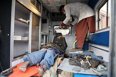 A survivor is treated in an ambulance at the site of a late-Monday airstrike at a drug rehabilitation hospital in Kabul, Afghanistan.