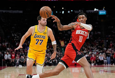 Houston Rockets' Jabari Smith Jr. (10) passes the ball as Los Angeles Lakers' Luka Doncic (77) defends during the second half of an NBA basketball game in Houston. 