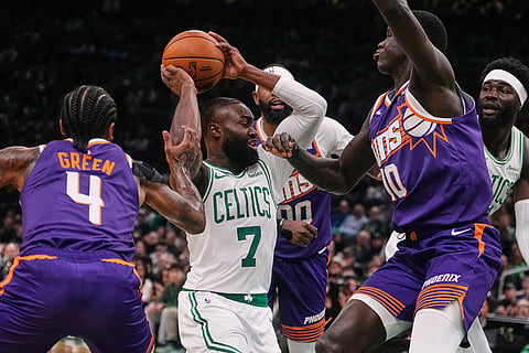 Boston Celtics guard Jaylen Brown (7) is surrounded on a drive to the basket against the Phoenix Suns during the first half of an NBA basketball game in Boston.