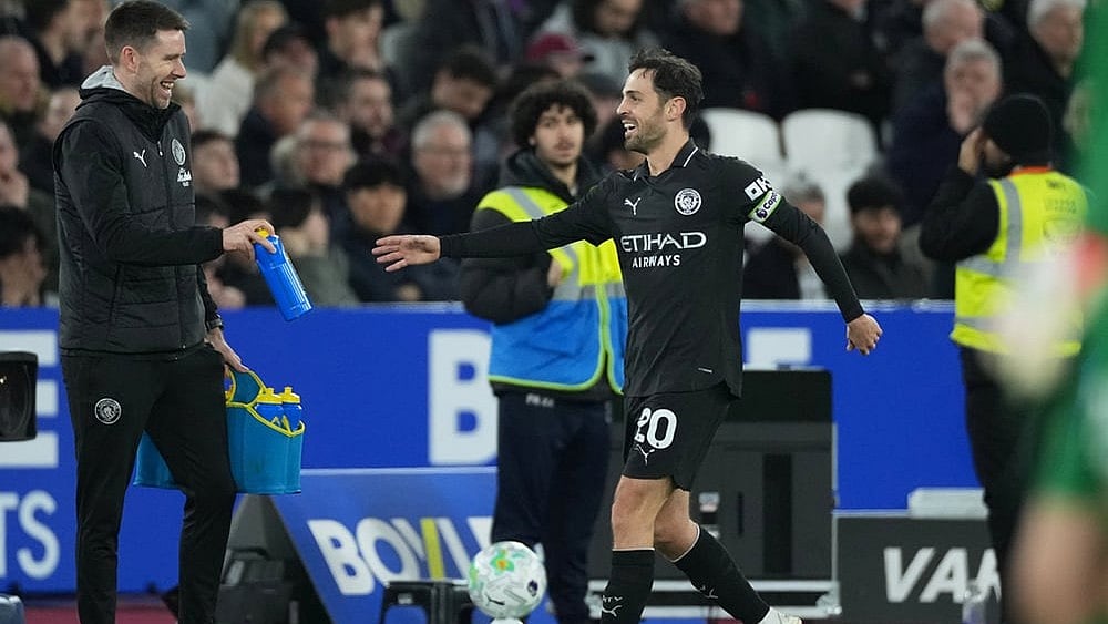 Photo: AP/Dave Shopland : Manchester City's Bernardo Silva, right, reacts after scoring his side's opening goal during the English Premier League soccer match between West Ham United and Manchester City in London, England.