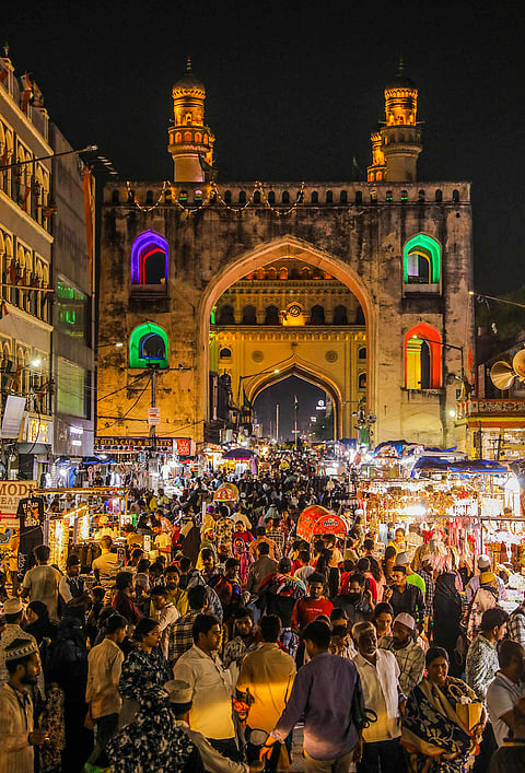 People shop at a busy street market near Charminar decorated with lights during Ramzan ahead of Eid al-Fitr, in Hyderabad.