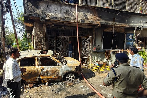 Indore: Police personnel and people gather as a rescue operation is underway after a fire broke out in a house, in Indore, Madhya Pradesh. Seven persons were killed in the incident, officials said.
