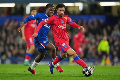PSG's Warren Zaire-Emery, right, challenges for the ball with Chelsea's Romeo Lavia during the Champions League soccer match between Chelsea and Paris Saint-Germain in London, England.