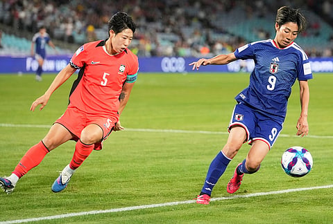 Japan's Riko Ueki, right, and South Korea's Ko Yoo-jin battle for the ball during the Women's Asian Cup semifinal soccer match between Japan and South Korea in Sydney.